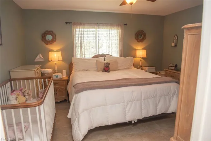 Tiled bedroom featuring ceiling fan