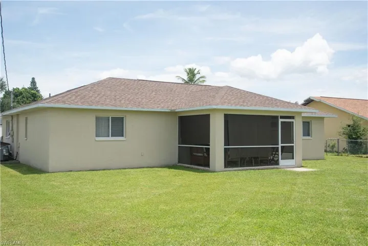 Back of house with a sunroom and a yard