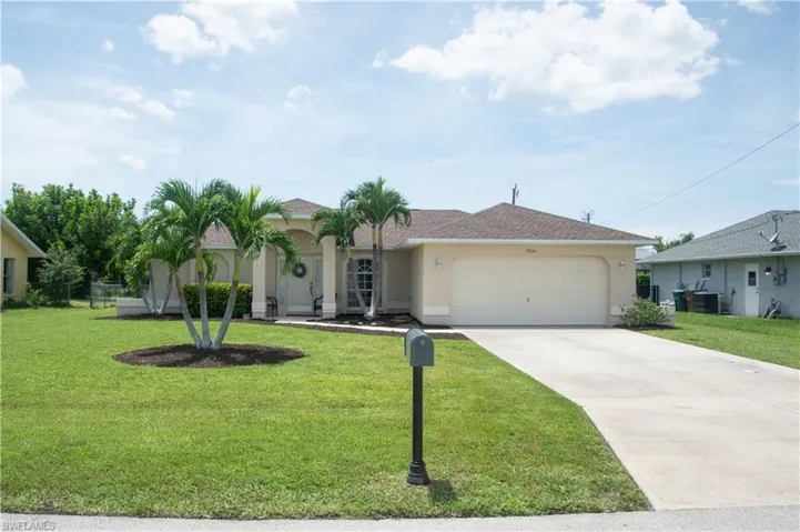Ranch-style house with a garage and a front lawn