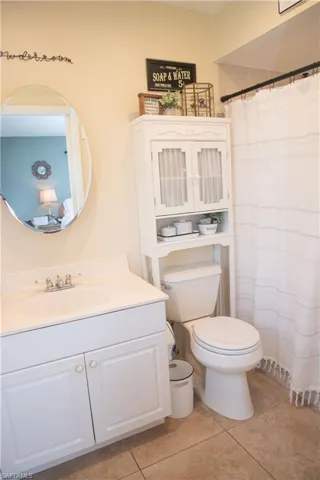 Bathroom featuring vanity, tile patterned flooring, and toilet