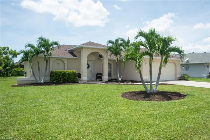 View of front facade featuring a garage and a front yard