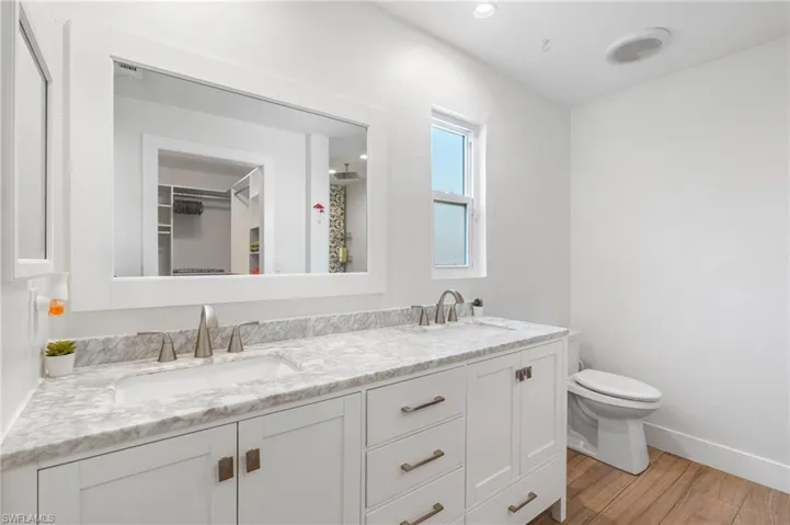 Bathroom featuring wood-type flooring, toilet, and vanity