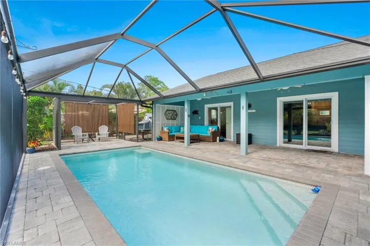 View of swimming pool featuring ceiling fan, outdoor lounge area, a patio area, and a lanai