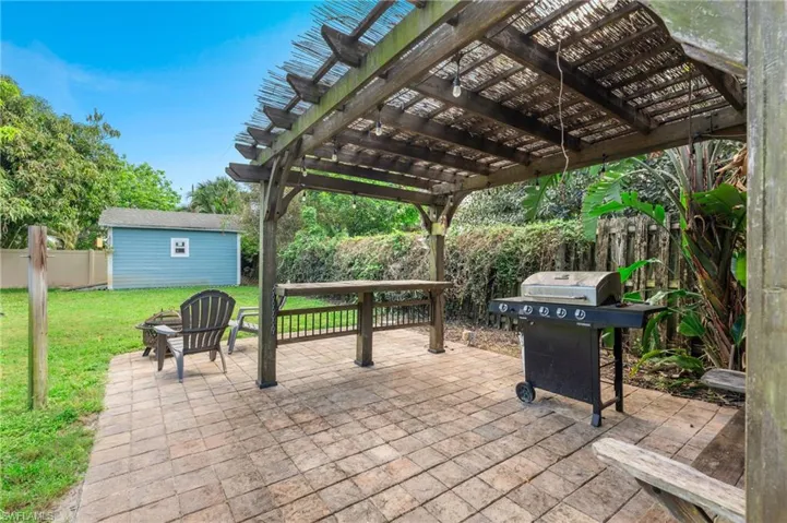View of patio with grilling area, a storage shed, a pergola, and a fire pit
