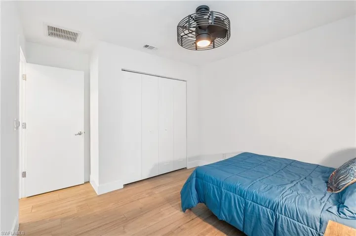 Bedroom with ceiling fan, light hardwood / wood-style floors, and a closet