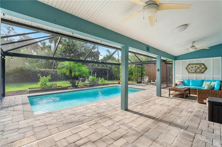 View of swimming pool with an outdoor hangout area, a patio area, ceiling fan, and glass enclosure