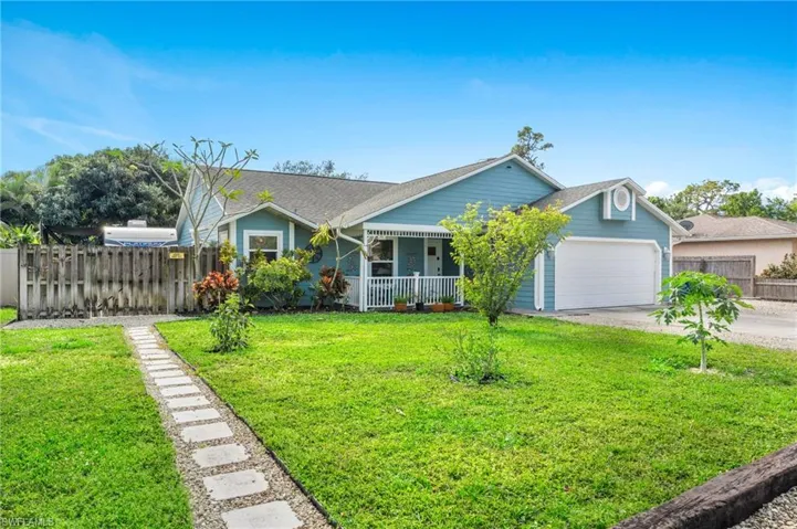 View of front of home featuring a garage, covered porch, and a front yard