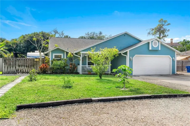 View of front of home featuring a porch, a garage, and a front yard