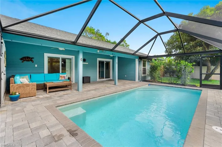 View of swimming pool with an outdoor living space, a patio area, ceiling fan, and glass enclosure