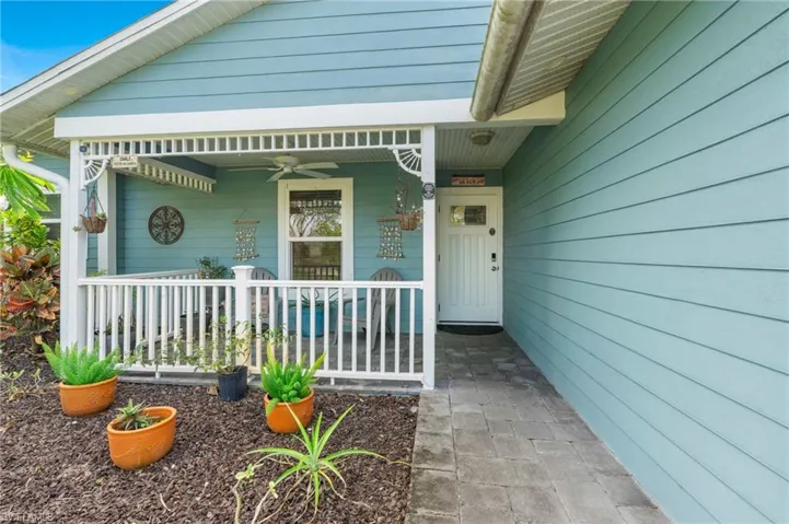 Doorway to property featuring ceiling fan and covered porch