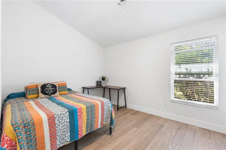 Bedroom featuring lofted ceiling and light hardwood / wood-style flooring