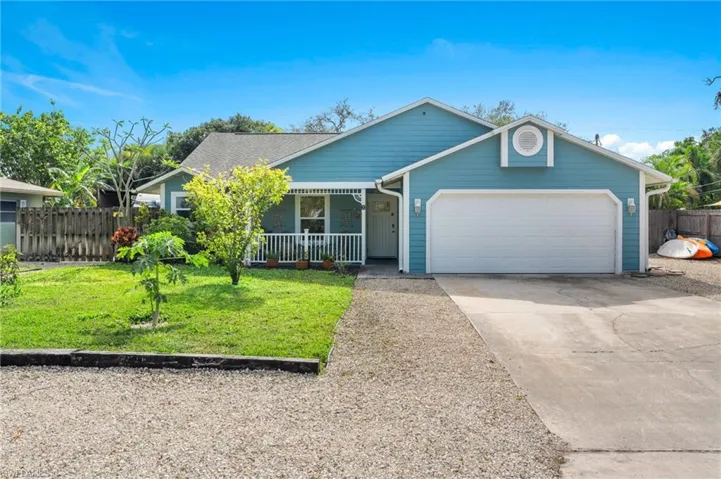 View of front of property with a garage, a front lawn, and a porch