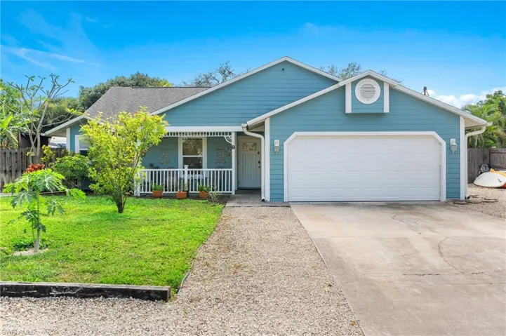View of front of house with a garage, a front lawn, and a porch