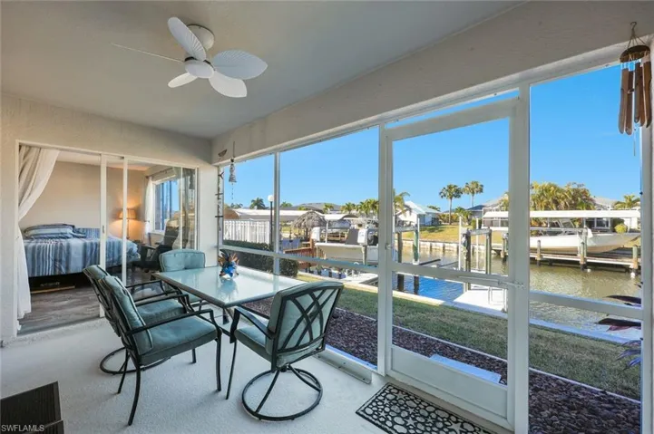 Sunroom / solarium featuring ceiling fan, outdoor dining space, a water view, and a residential view