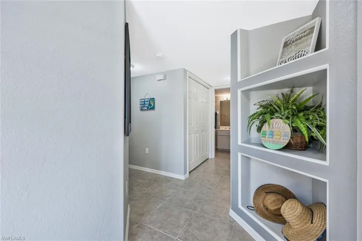 Corridor featuring a textured wall and light tile patterned floors