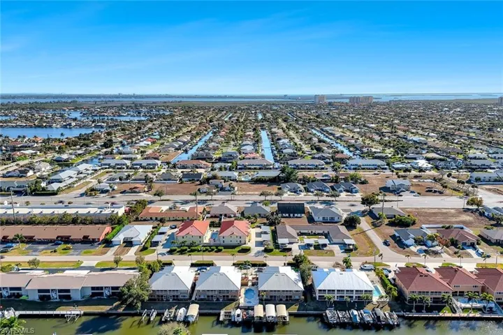 Aerial perspective of suburban area featuring a nearby body of water