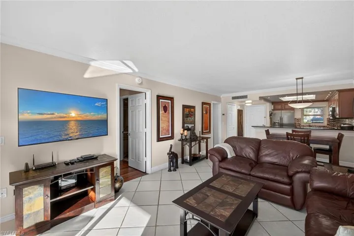 Living room with ornamental molding and light tile patterned flooring