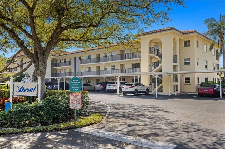 View of apartment building / complex with covered parking