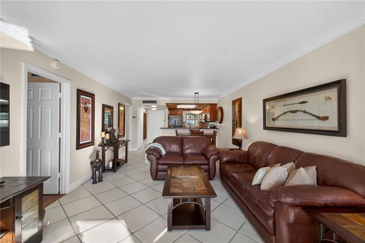 Living area featuring ornamental molding and light tile patterned floors