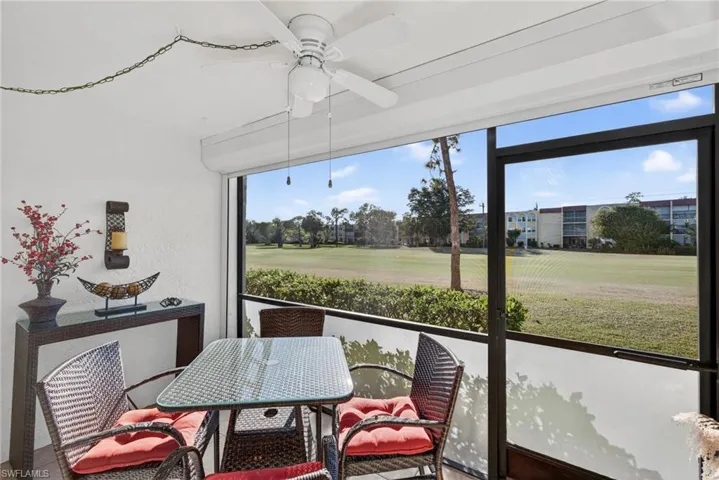 Sunroom with a ceiling fan, outdoor dining space, and view of golf course