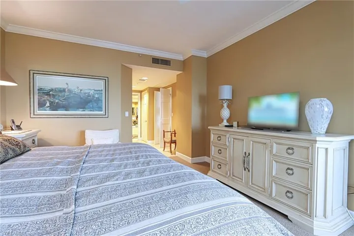 Carpeted bedroom with ornamental molding