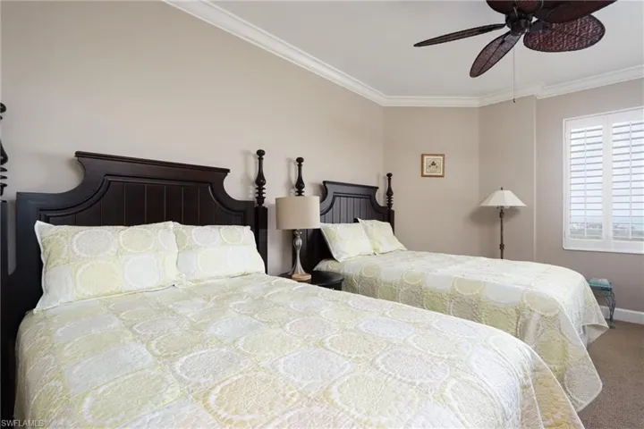 Bedroom with carpet, ceiling fan, and crown molding