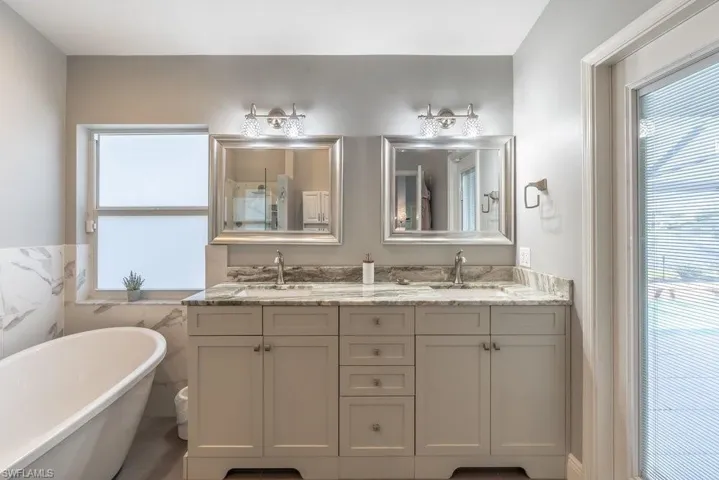 Primary bath with access to lanai/pool, dual sinks and separate tub and shower.