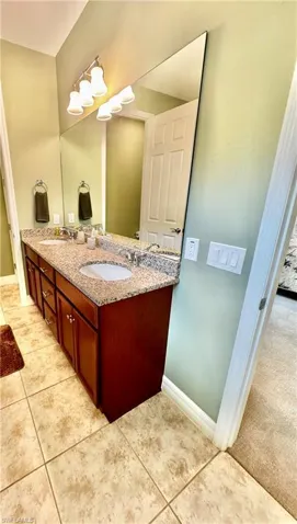 Bathroom featuring double vanity and light tile patterned floors