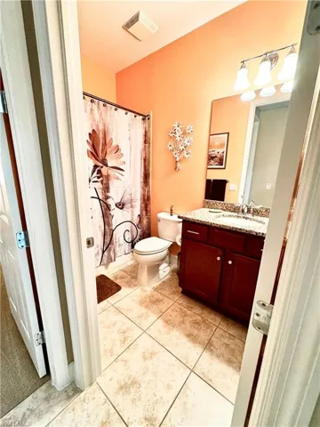 Bathroom featuring vanity, light tile patterned flooring, and a shower with shower curtain