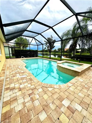 View of pool with a sunroom, a water view, a lanai, a patio, and a pool with connected hot tub
