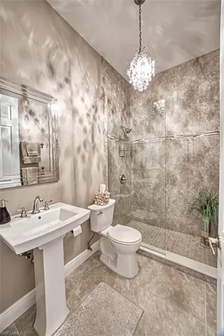 Bathroom featuring a tile shower, tile patterned flooring, and toilet