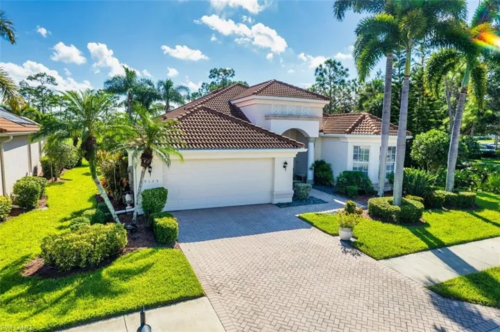 Mediterranean / spanish-style home featuring a garage and a front yard