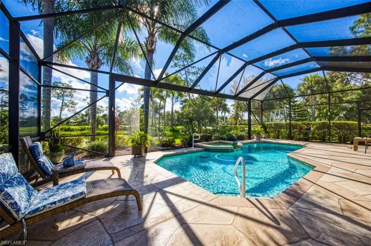 View of pool featuring an in ground hot tub, glass enclosure, and a patio area