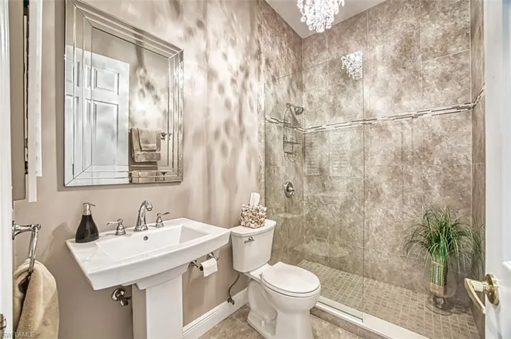 Bathroom featuring tile patterned flooring, tiled shower, and toilet