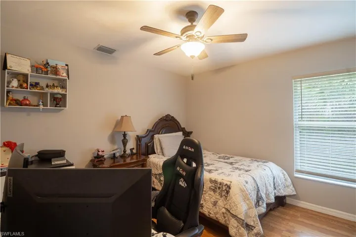 Bedroom with wood finished floors, baseboards, and a ceiling fan
