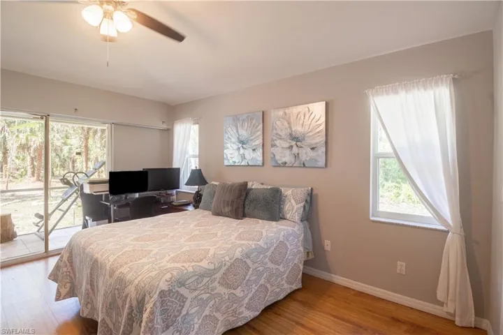 Bedroom with access to outside, wood finished floors, baseboards, and ceiling fan