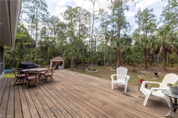 Wooden terrace with outdoor dining area and an outbuilding
