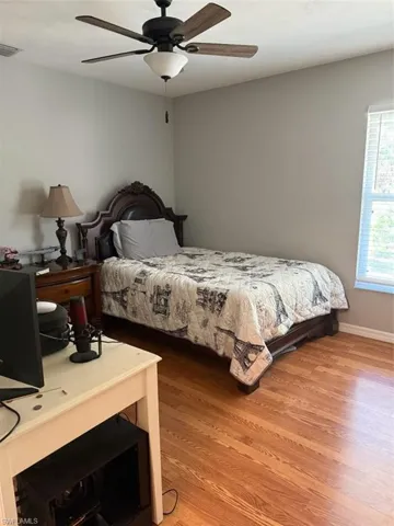 Bedroom featuring visible vents, multiple windows, baseboards, and light wood-style floors