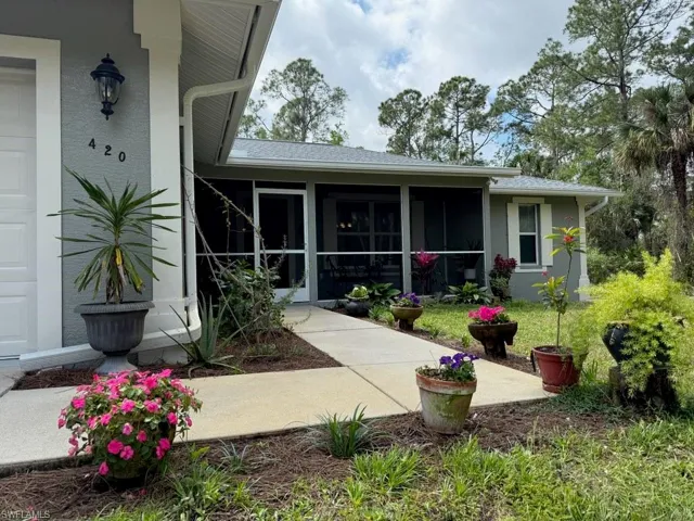 Rear view of property featuring stucco siding and a sunroom