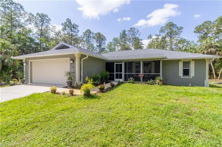Single story home featuring stucco siding, a garage, driveway, and a sunroom
