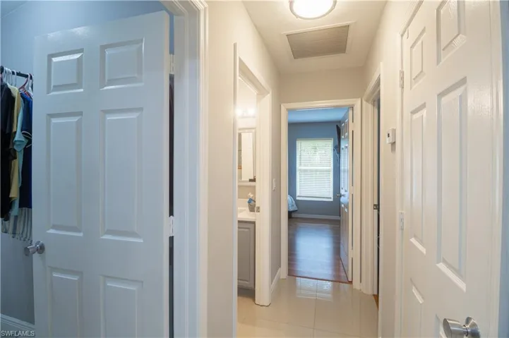 Hall featuring light tile patterned floors and baseboards