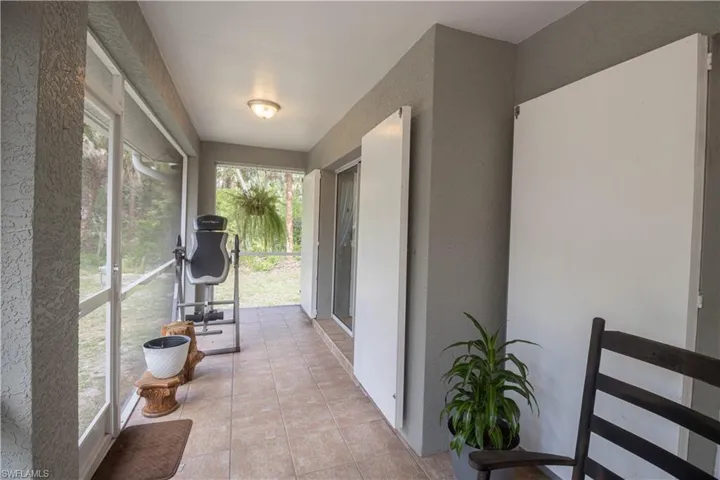 Sunroom / solarium featuring tile patterned floors and a textured wall
