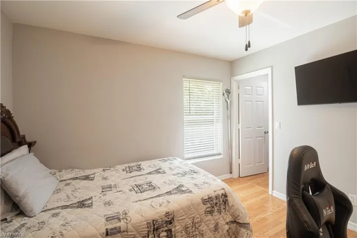 Bedroom with light wood finished floors, a ceiling fan, and baseboards