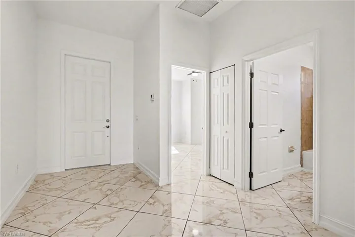 Entryway with light marble finish floors and baseboards