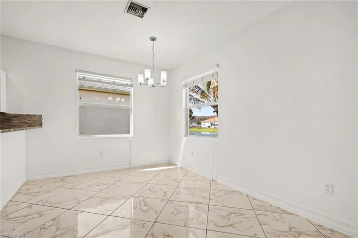 Unfurnished dining area with light marble finish flooring and suspended lighting