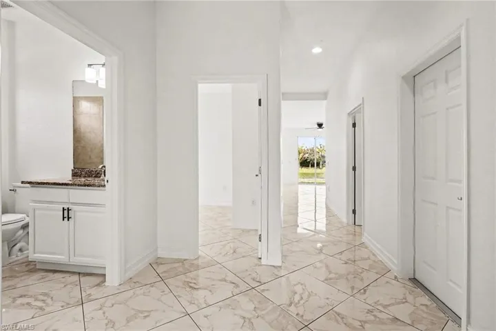 Full bathroom featuring light marble finish floors, vanity, and recessed lighting