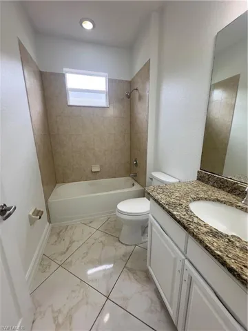 Unfurnished bedroom featuring access to outside, a ceiling fan, light marble finish floors, and a closet