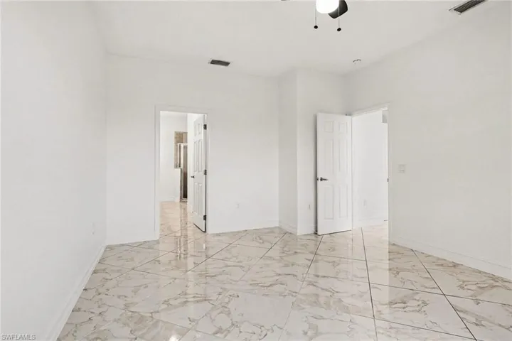 Unfurnished bedroom with a ceiling fan and light marble finish flooring