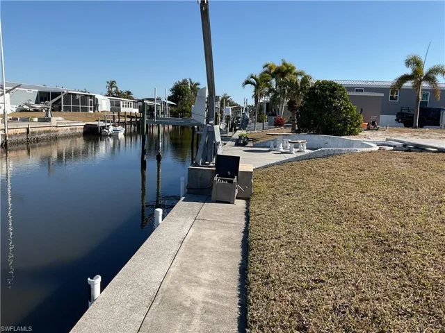 Dock with a water view and a lawn