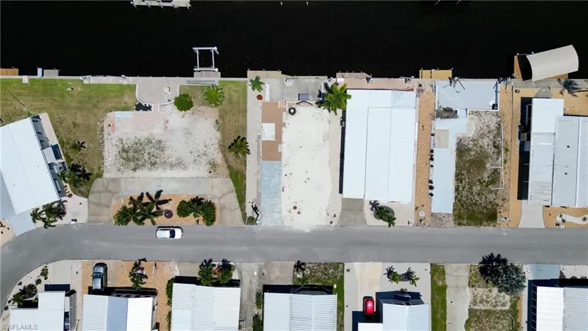 Aerial overview of property's with view of the water and beautiful palm trees across the front of the property.